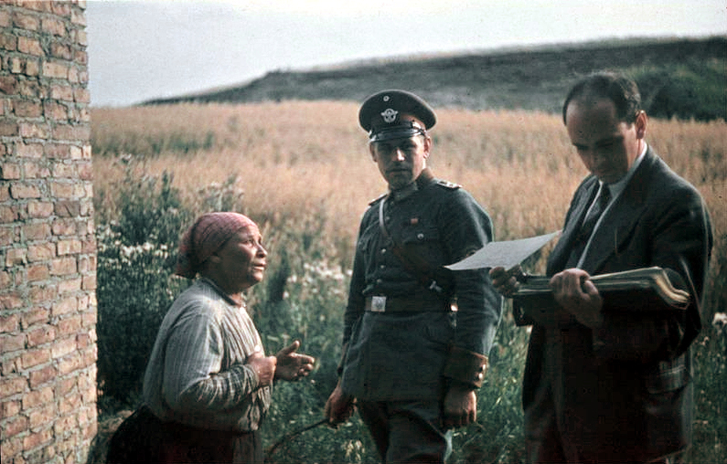 Robert Ritter (r.) liest in einer Aktenmappe.